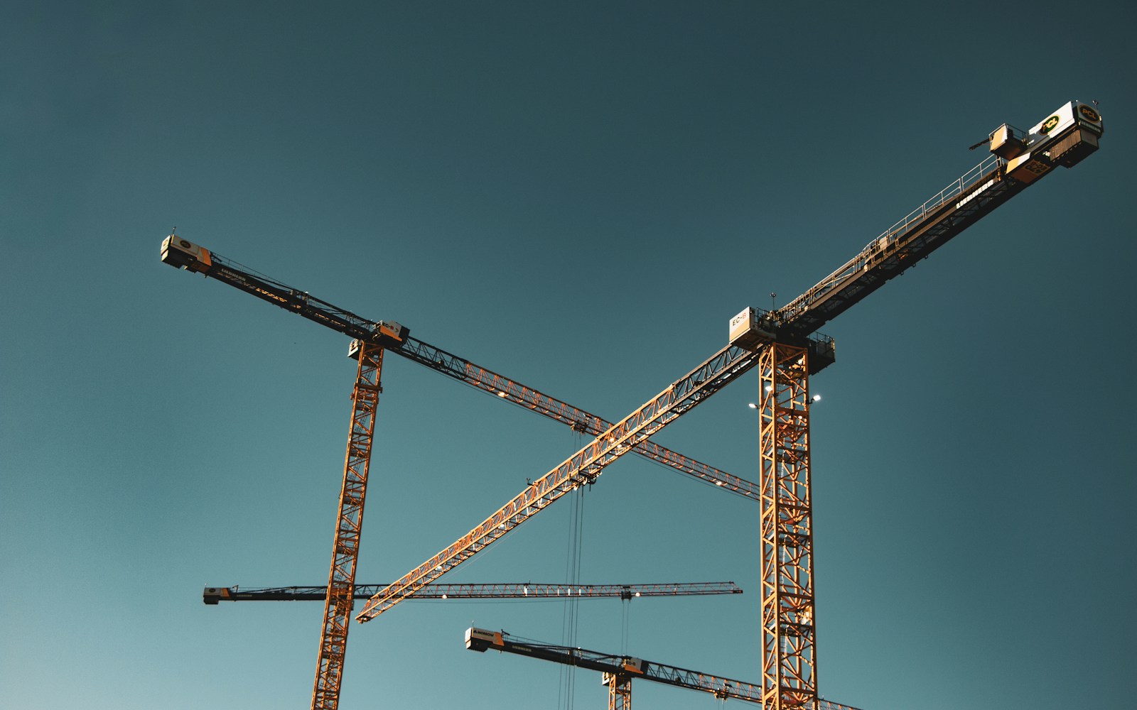 Tower cranes against an open sky. Generic industry context.