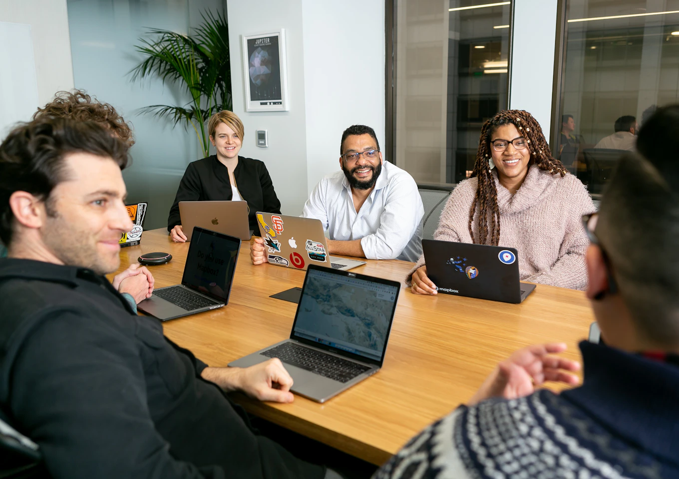 Consultancy team working together around a meeting table with laptops