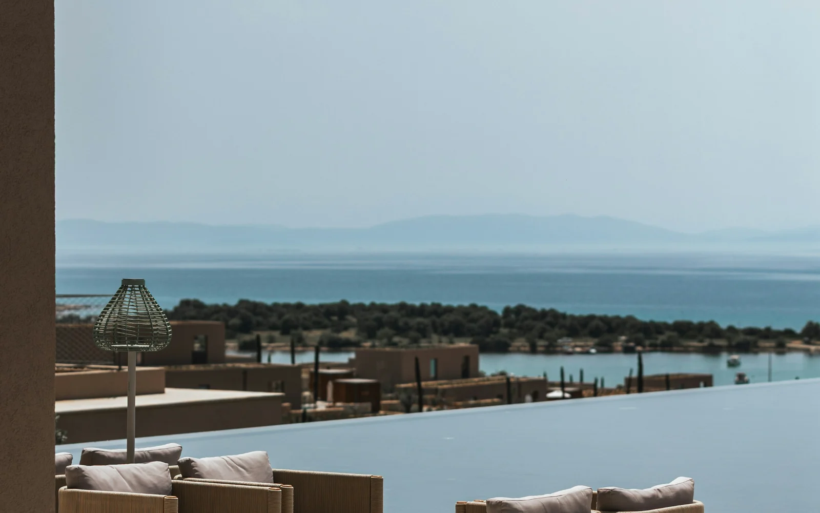 A Mediterranean resort terrace above a calm sea, with low buildings along the shore. Industry context, not the client or the assessed properties.
